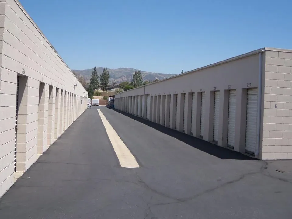 A row of small outdoor storage units with white doors in a clean area